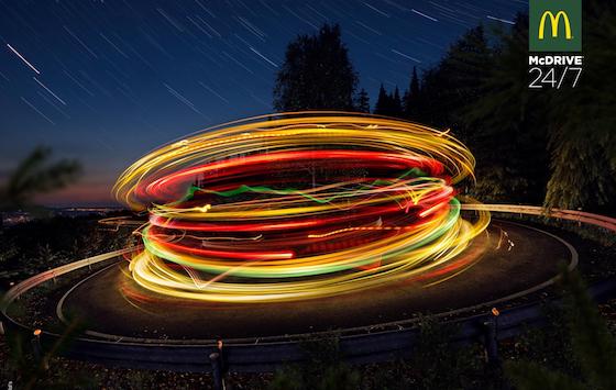 Simulated long exposure of car lights on roundabout creating impression of neon hamburger